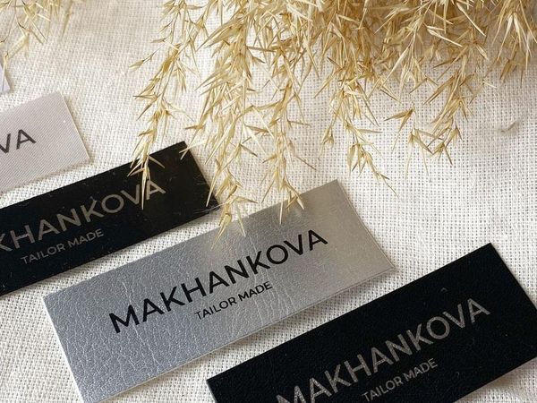 Премиальные пришивные нашивки: серебряная экокожа с черной печатью и черная экокожа с устойчивой серебряной печатью.